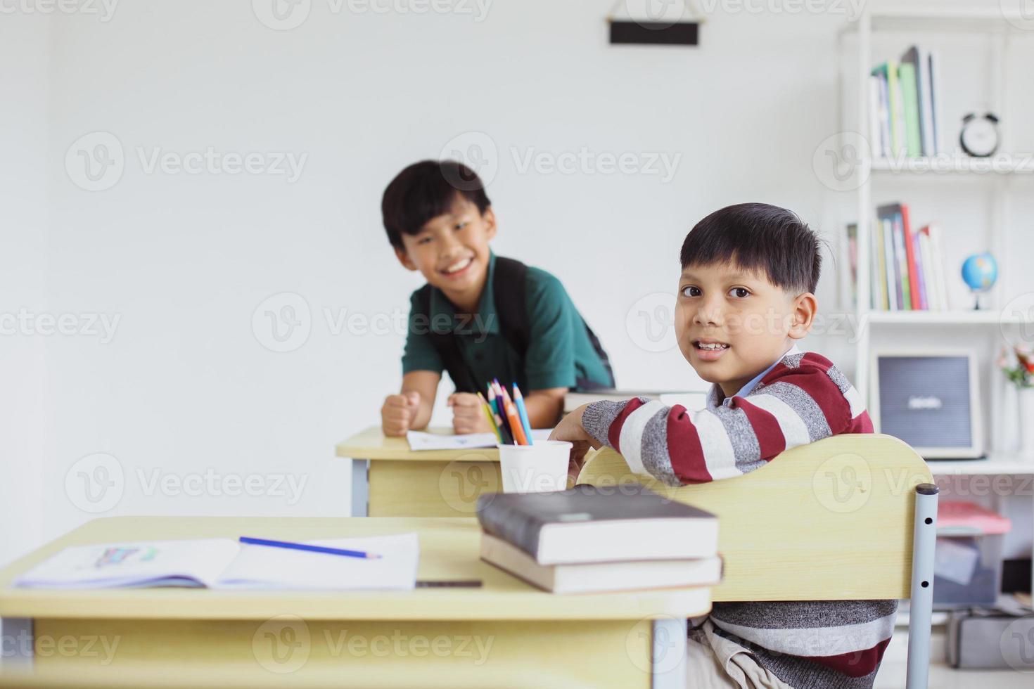 asiatiska skolpojkar poserar och tittar på kameran i klassrummet foto