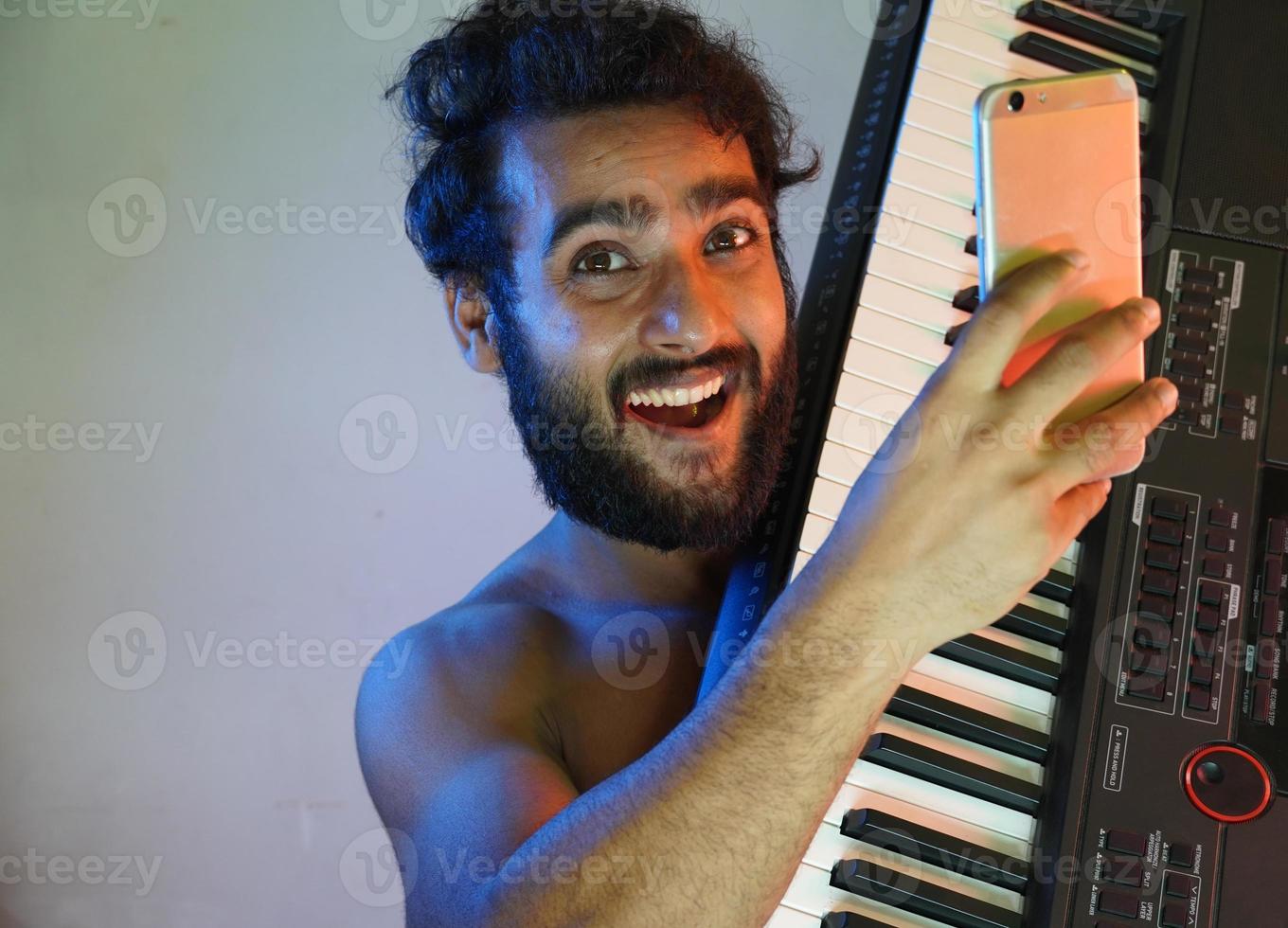 man med elektroniskt piano och tar selfie foto