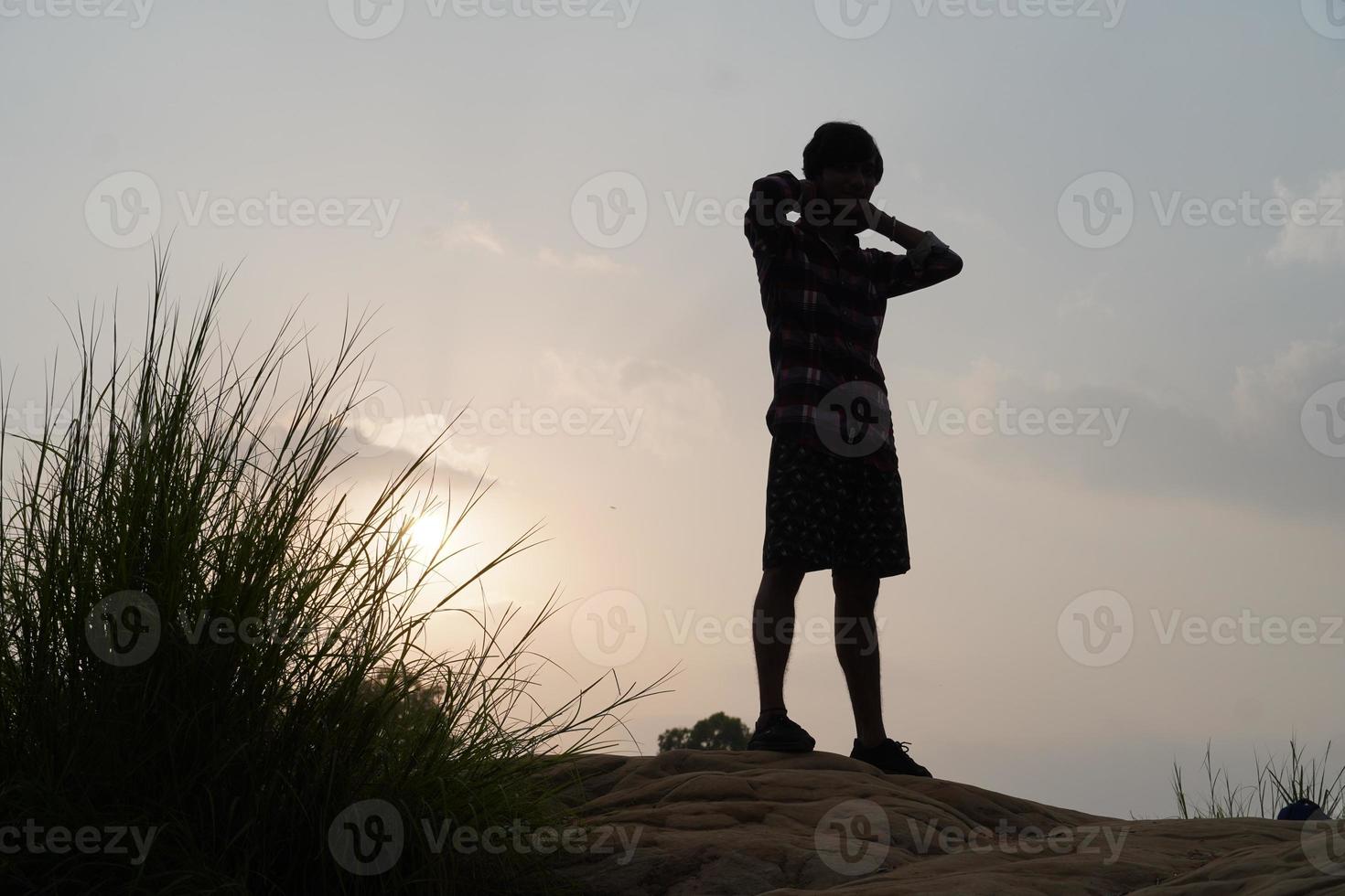 man på kvällen nära solen står foto