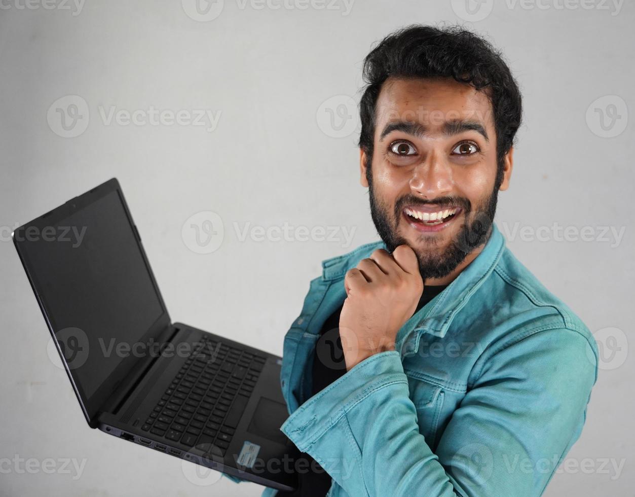 ung indisk pojke med en bärbar dator foto