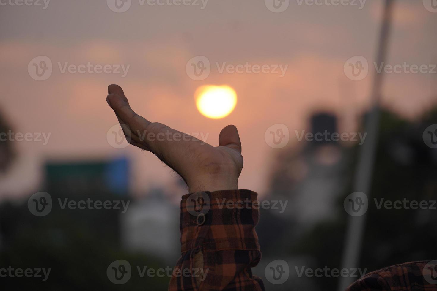 sol på kvällen en hand som försöker röra vid sol på kvällen foto