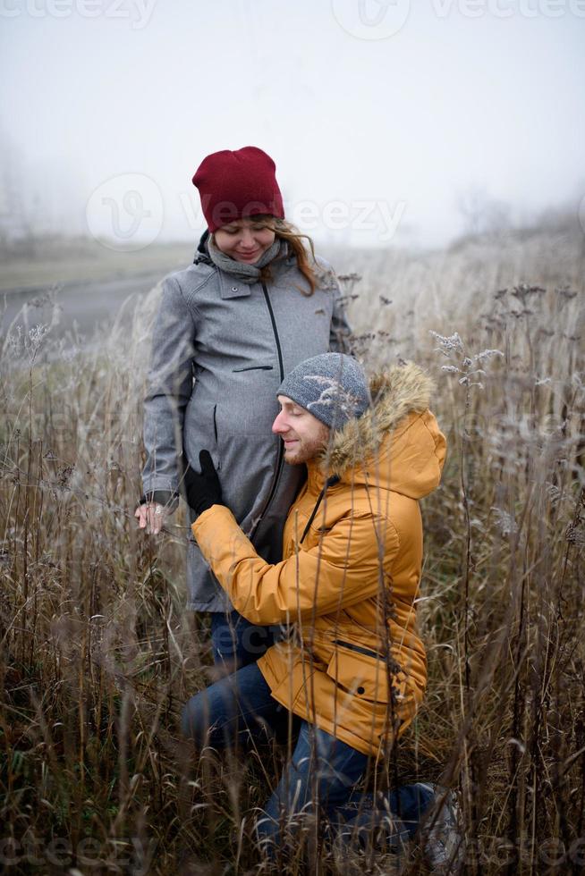 älskande gravida par går utanför staden på senhösten. foto