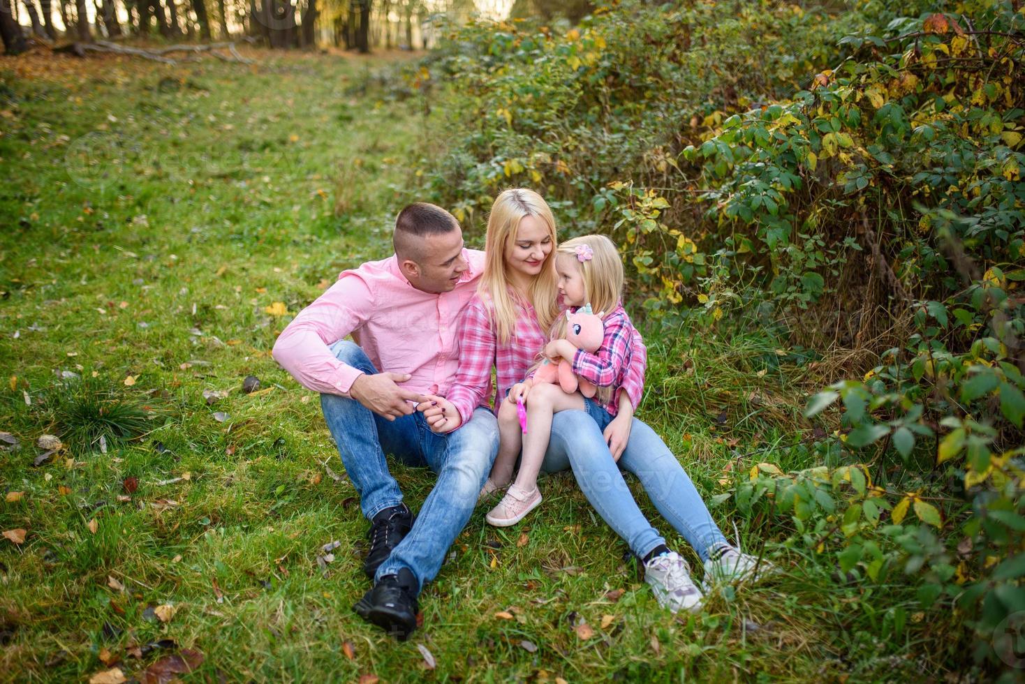 far, dotter och mamma går utomhus. glad familj. foto