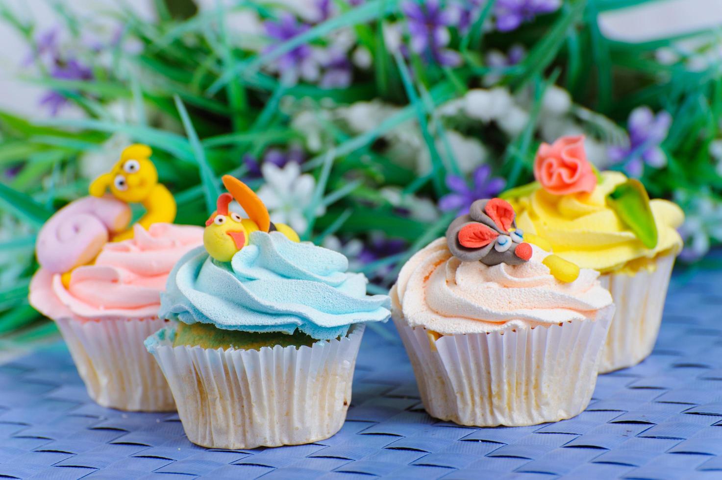 många cupcakes ligger med dekorationerna på huvudet foto