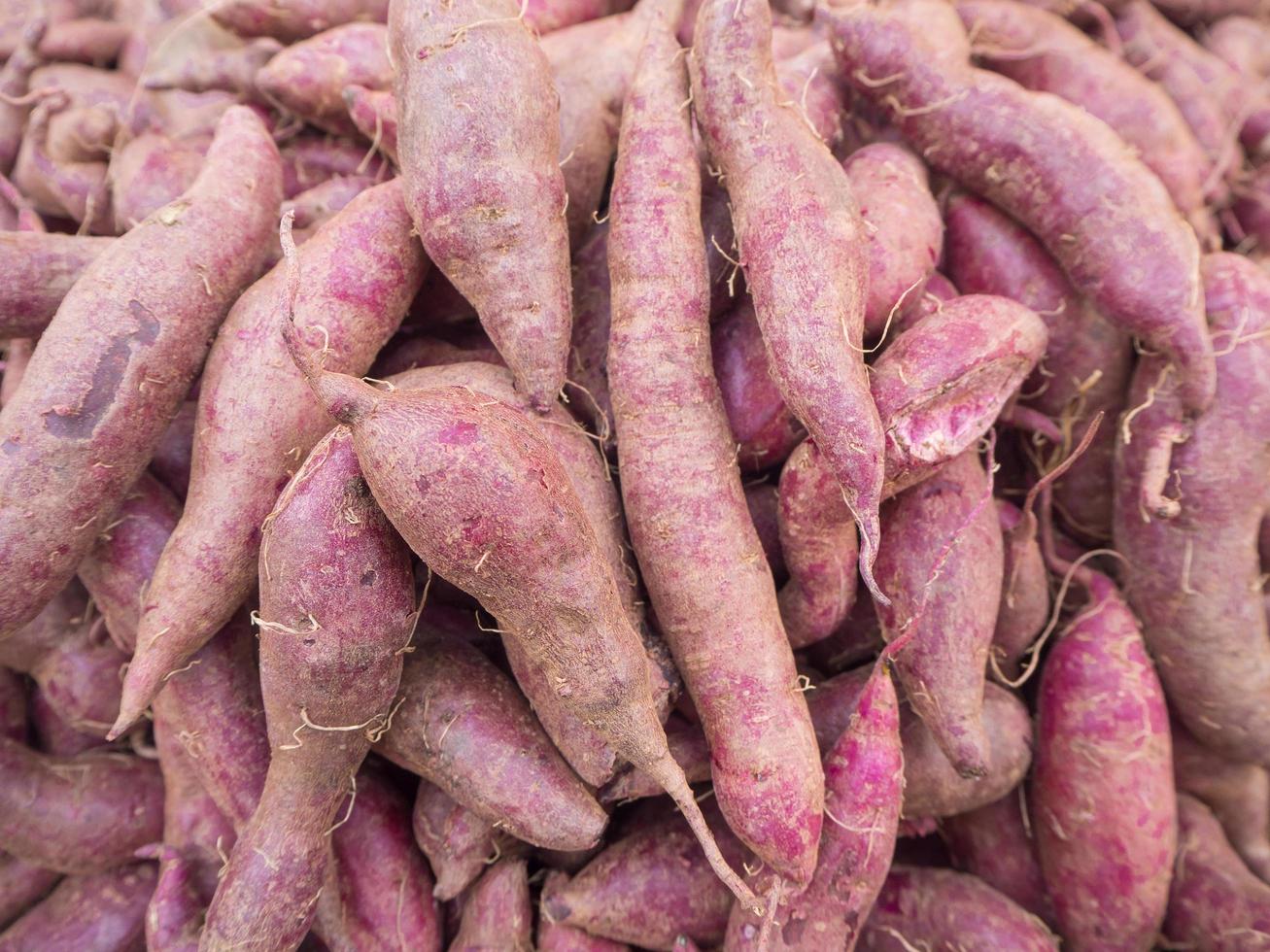 hög med färska lila yams på marknaden foto