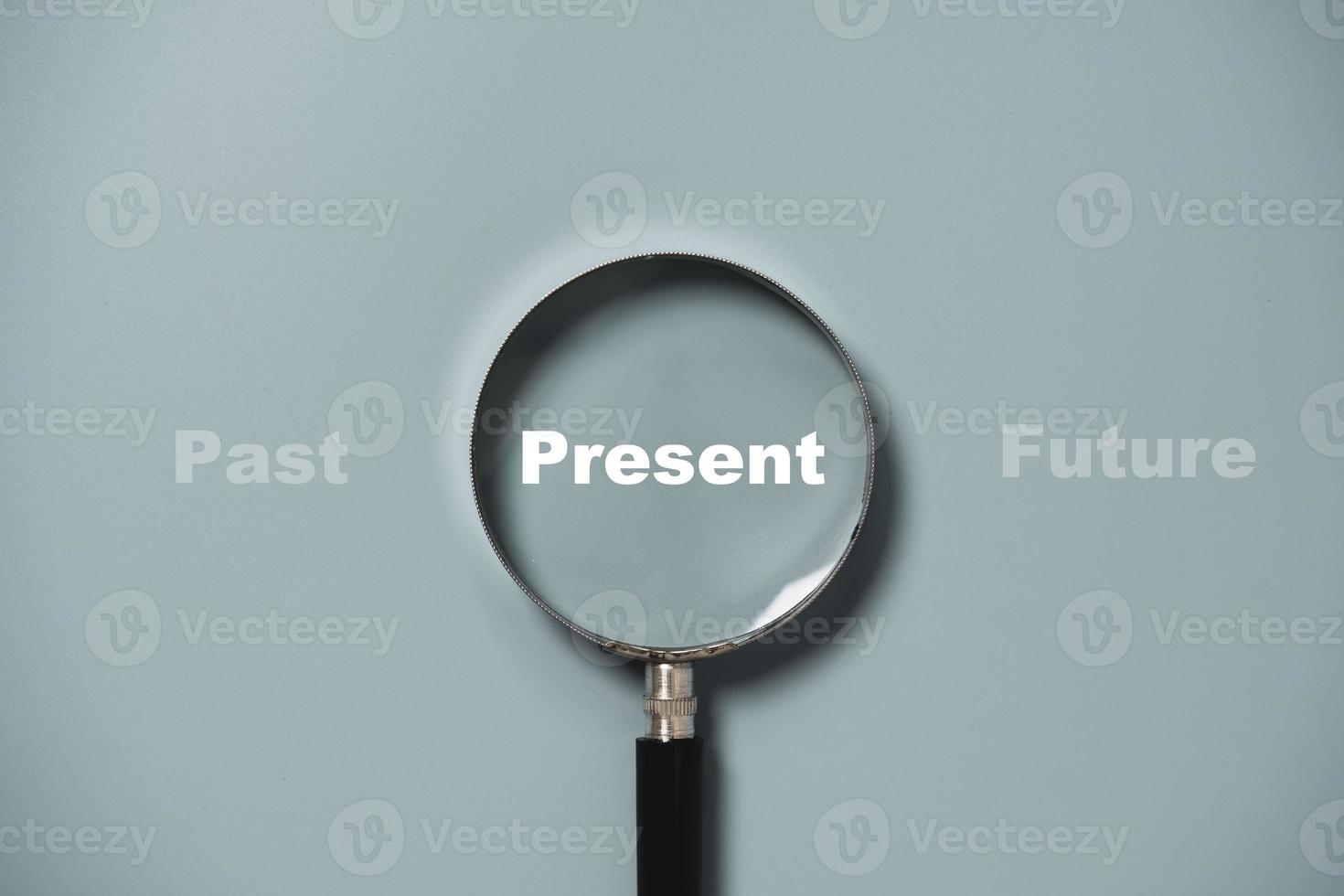 nuvarande formulering inuti förstoringsglas på blå bakgrund för fokus nuvarande situation, positivt tänkande tankesätt koncept. foto