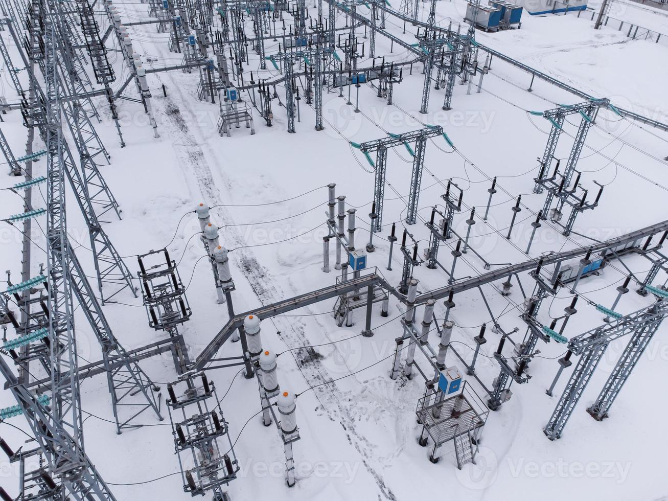 Flygfoto över en elektrisk högspänningstransformatorstation under vintersäsongen. foto