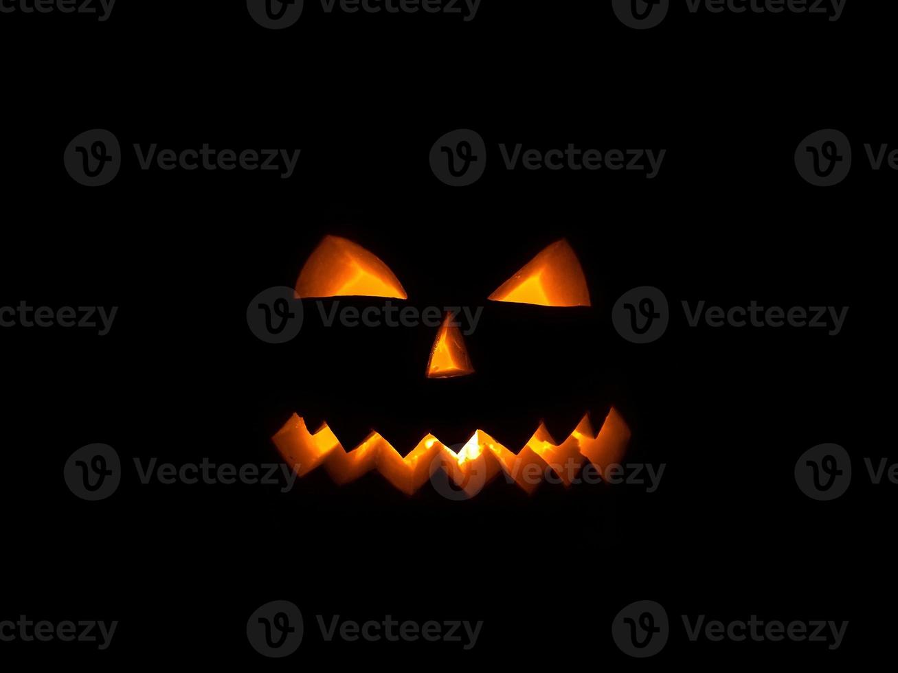 läskigt pumpaleende för halloween på en svart bakgrund. foto