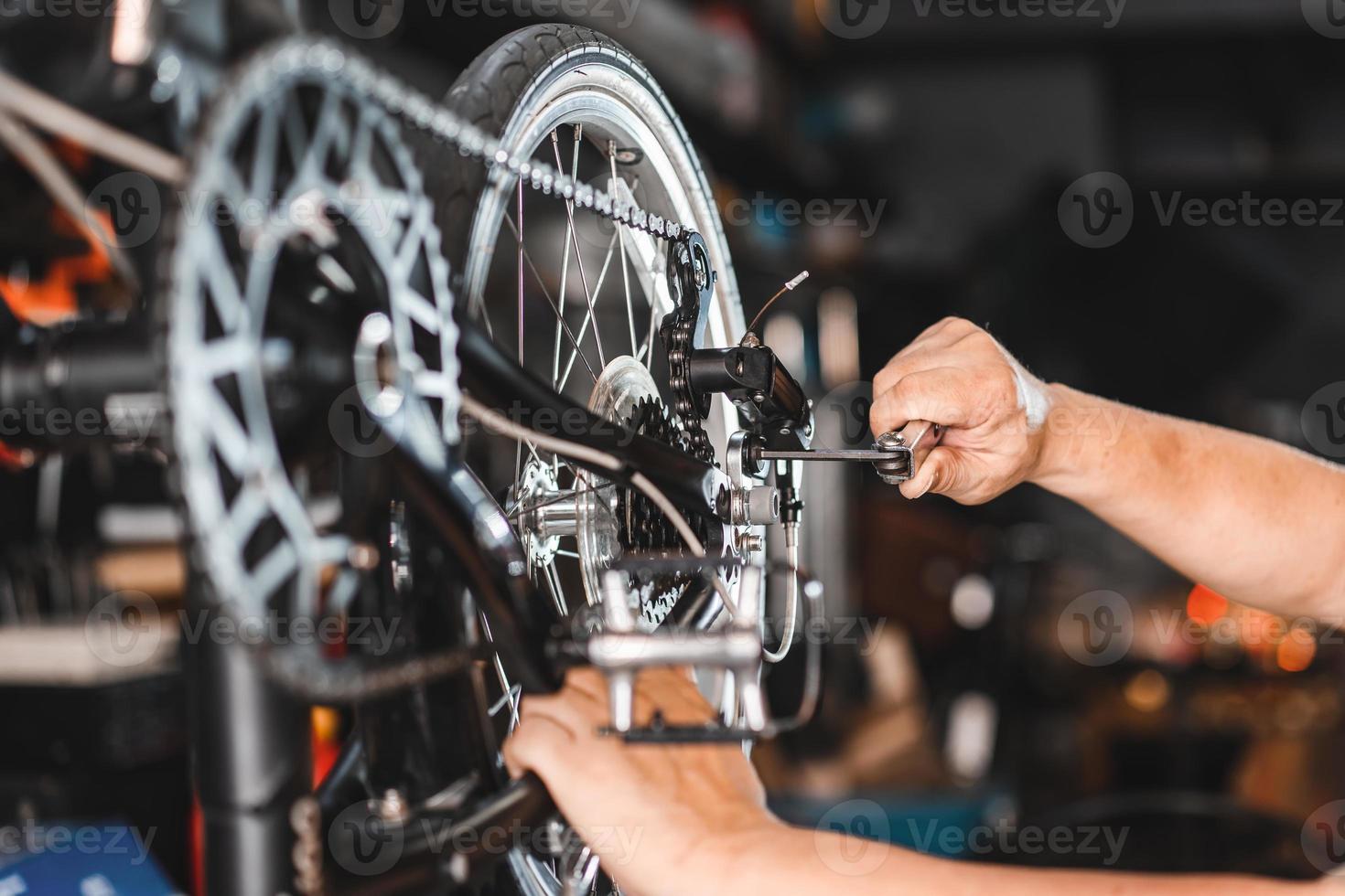 cykelmekaniker justerar bakväxeln och reparerar cykeln i verkstaden. , cykelunderhåll och reparationskoncept foto
