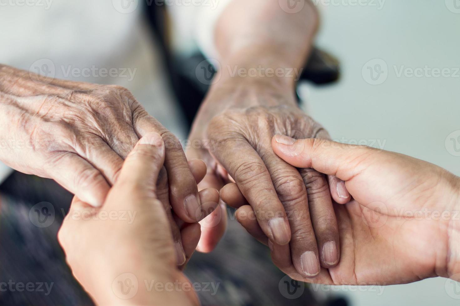 närbild händer på hjälpande händer äldre hemtjänst. mor och dotter. mental hälsa och äldreomsorg koncept foto