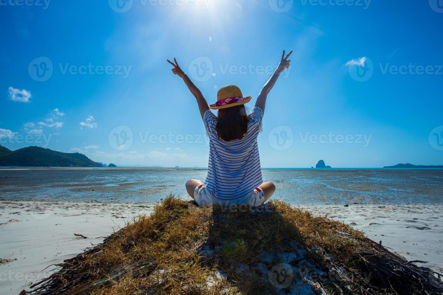 en kvinna känner sig glad att sitta på stranden tropisk utsikt över thailand. foto