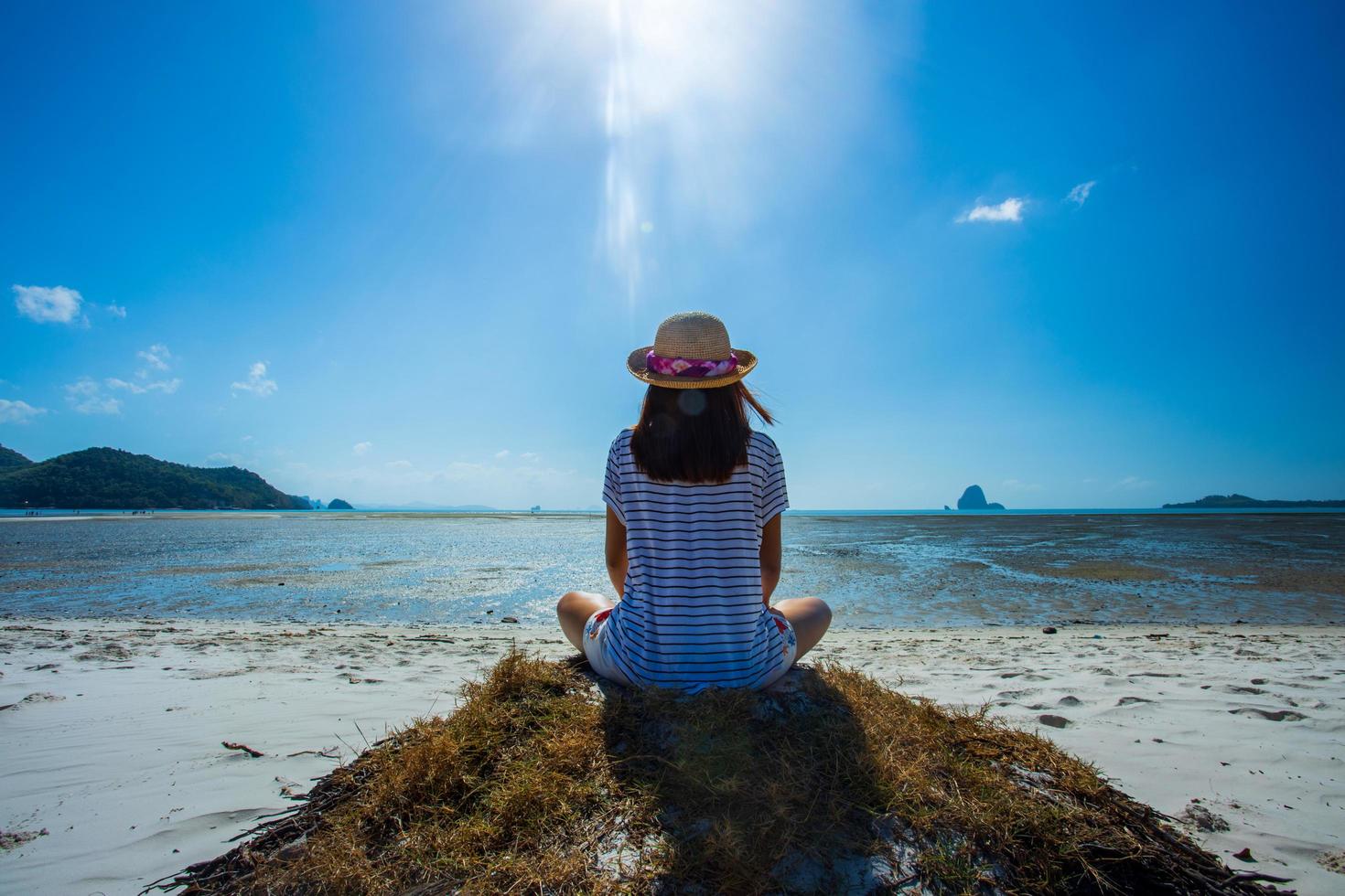 en kvinna känner sig glad att sitta på stranden tropisk utsikt över thailand. foto
