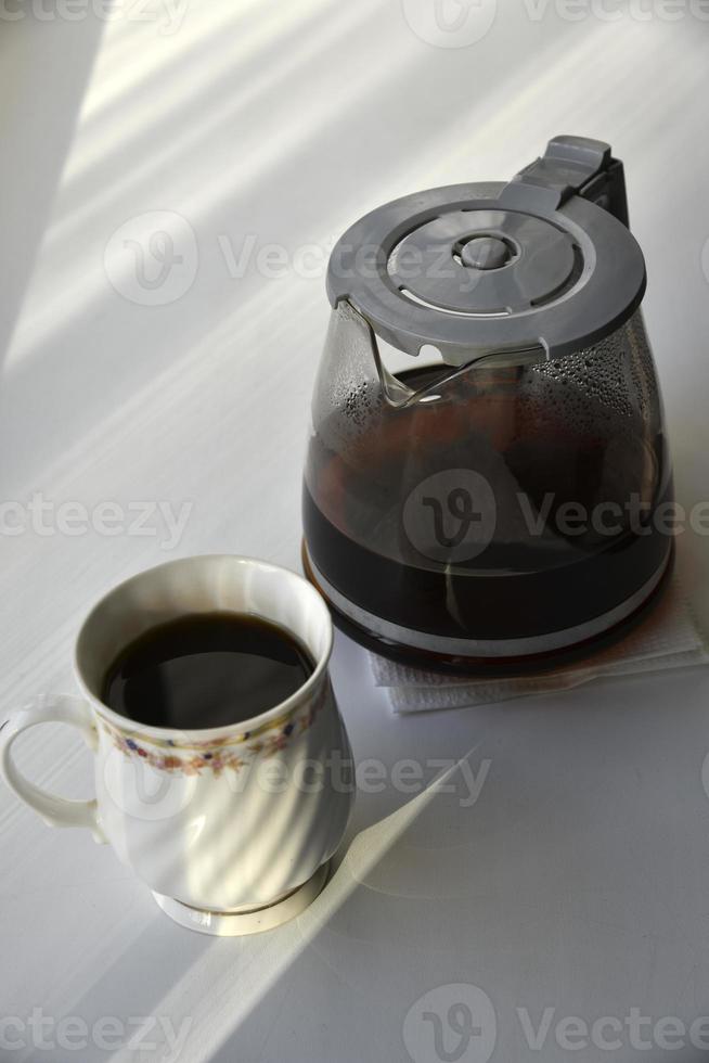 glas kaffekanna med en drink på en vit bakgrund foto
