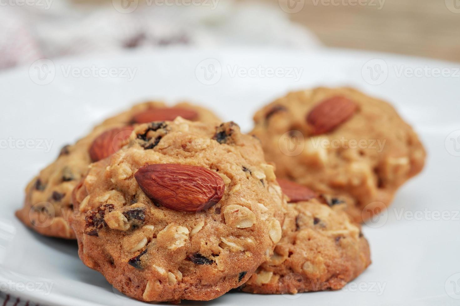 närbild mandel cookies eller hälsosamma snacks stack på en vit platta med en suddig bakgrund. foto