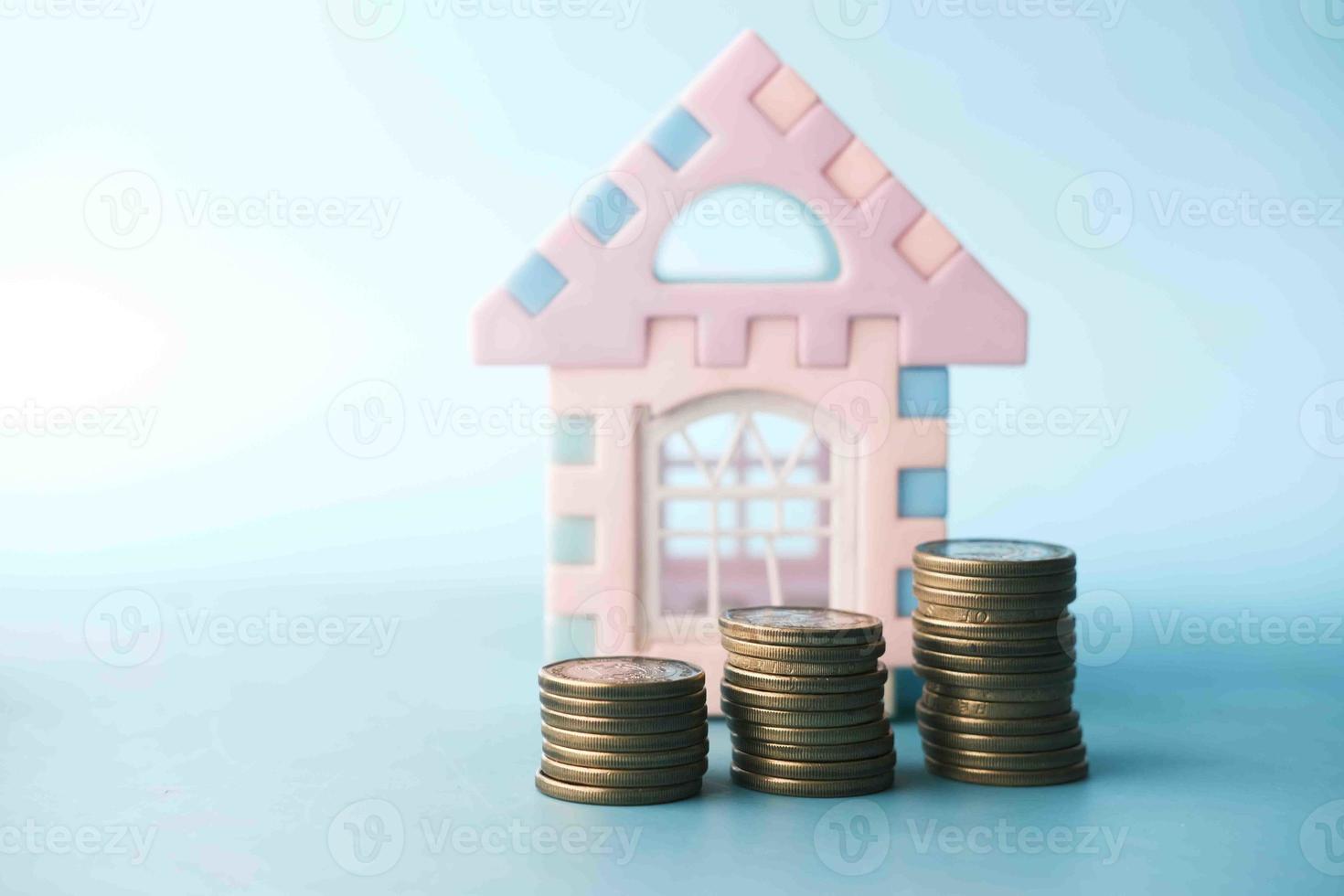 bunt med mynt och hus på bordet, begreppet husfinansiering foto