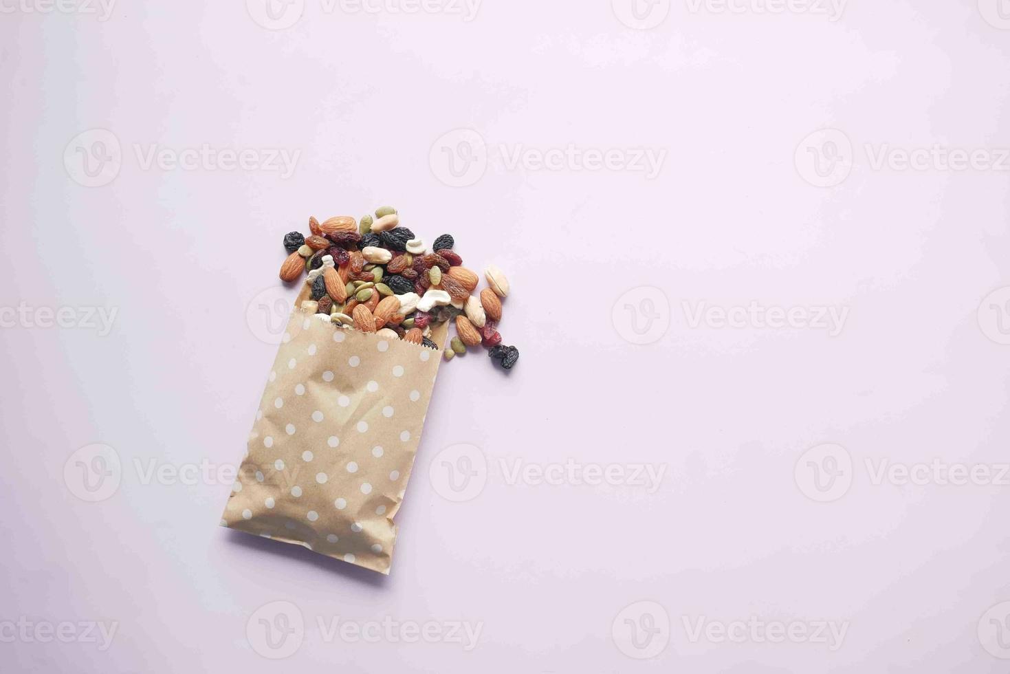 ovanifrån av många blandade nötter som spills från ett paket foto