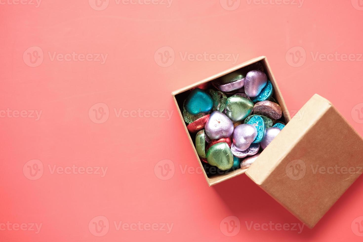 multi färg hjärta form godis i en låda på rött foto