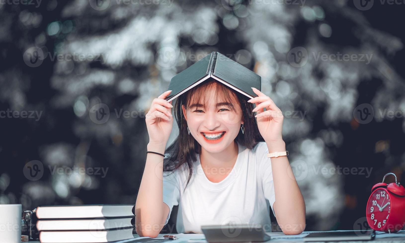 flicka leende framifrån av nöjda kvinnor läsa en bok i parken foto