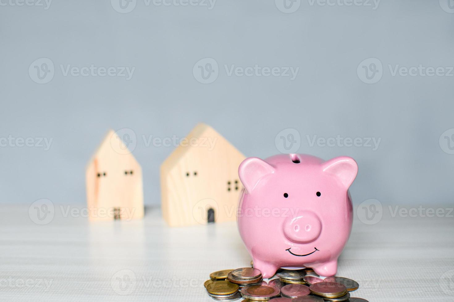 rosa gris spargris på en hög myntet placeras på en träbänk. koncept för finans, bank, besparingar, räntor, affärer, lån, skatt. närbild, kopiera utrymme på toppen för design, suddig bakgrund. foto