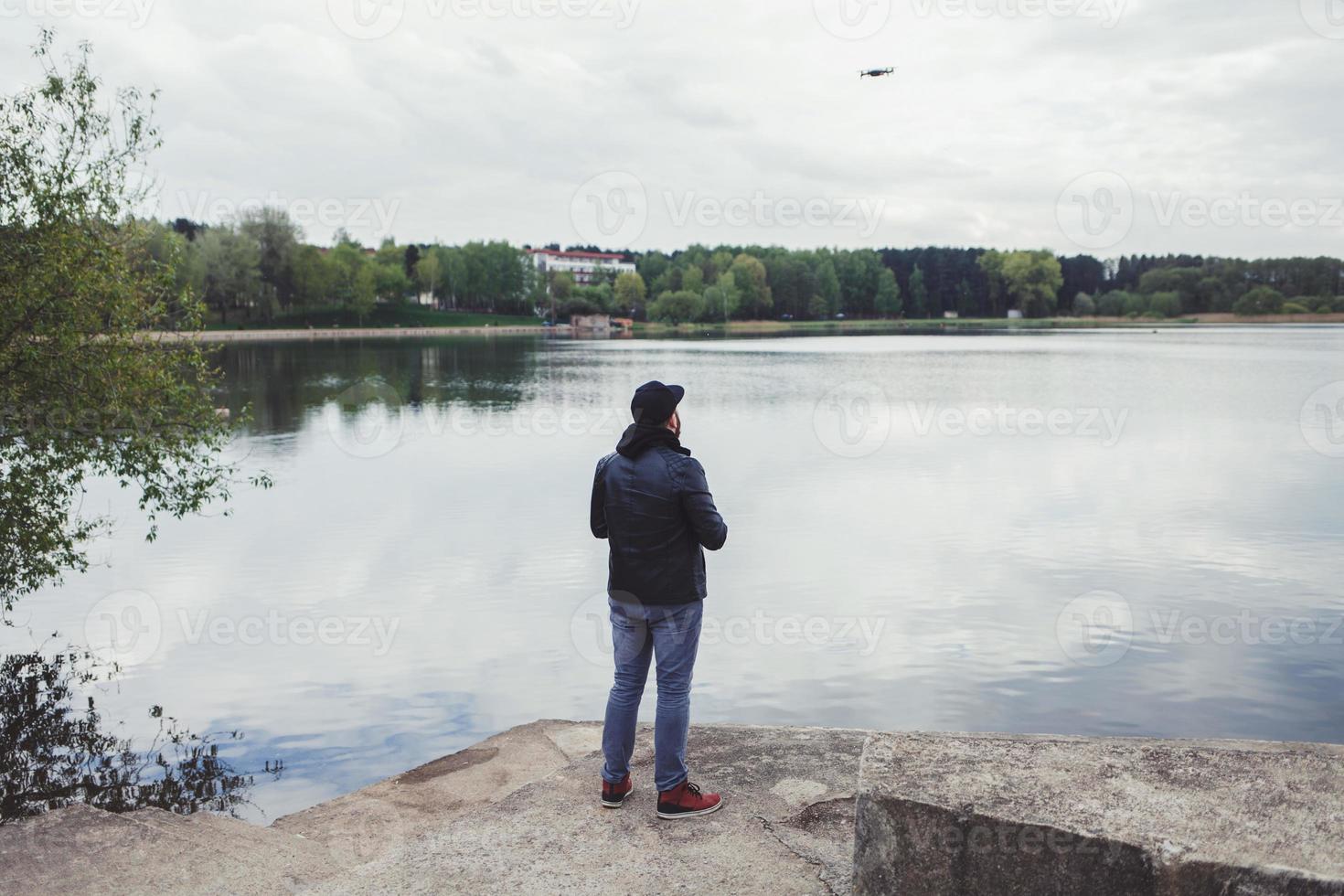 en man i skinnjacka styr en drönare foto