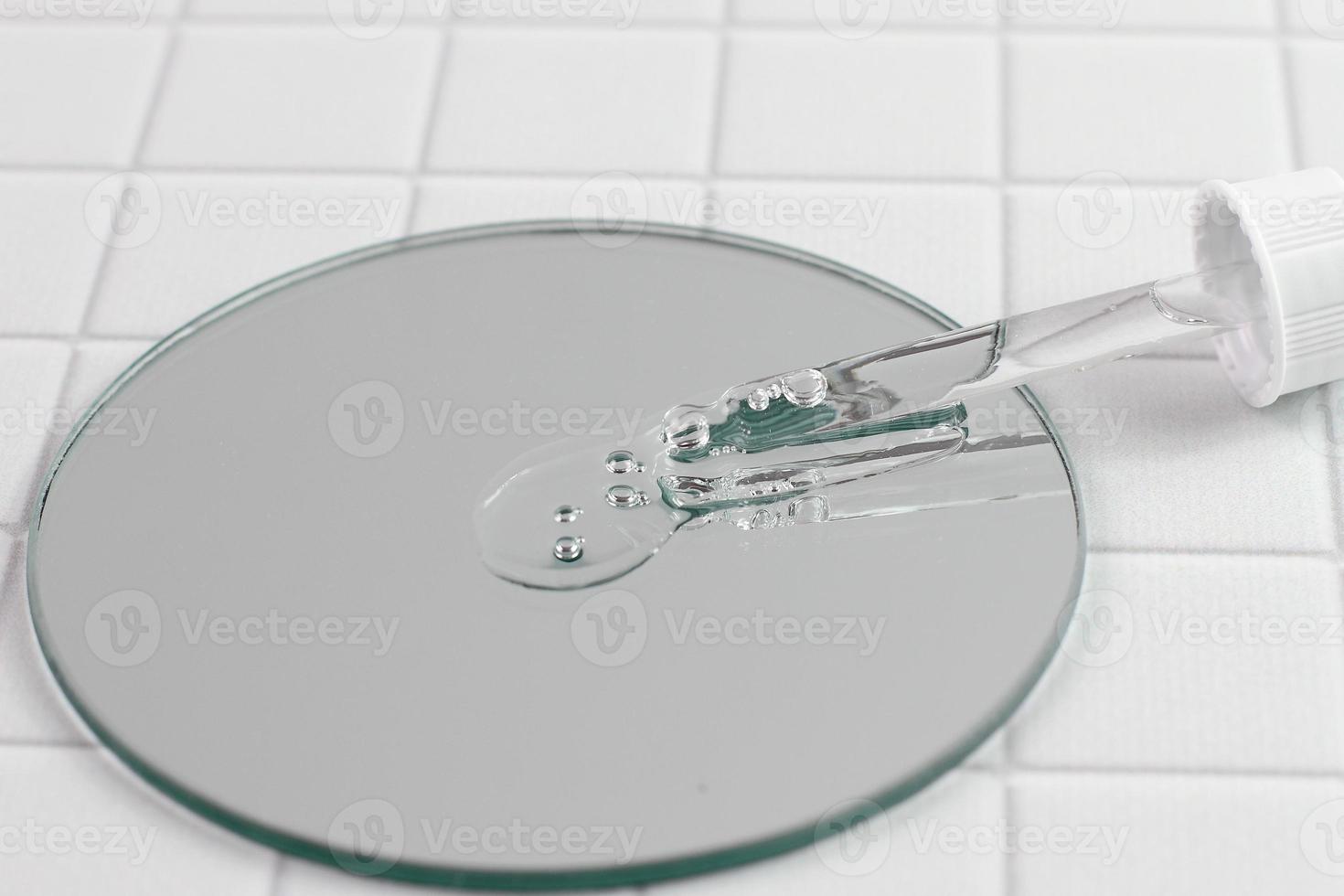 pipett och serumdroppar på spegel, kosmetisk produktion foto