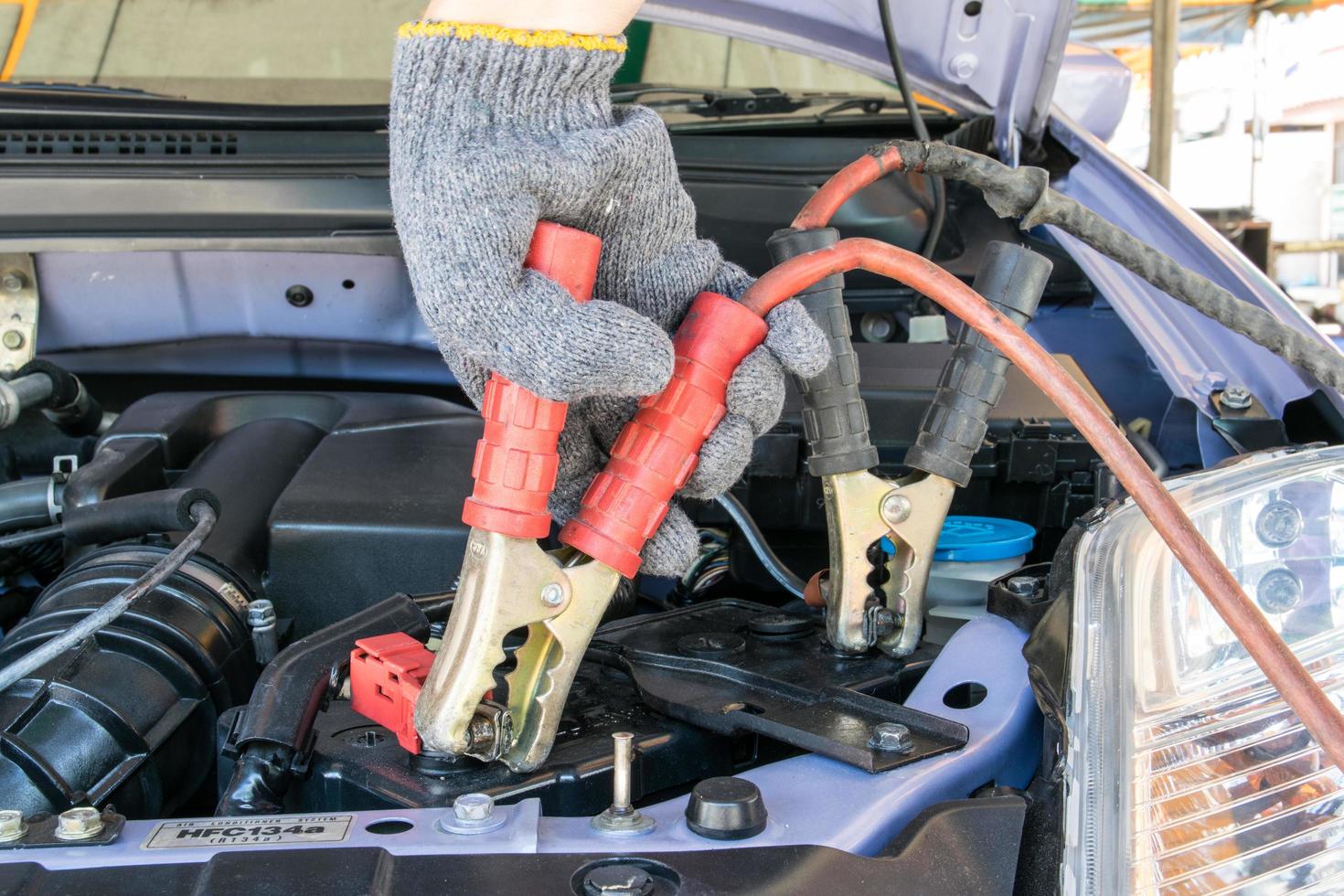 biltekniker som laddar fordonsbatteri foto