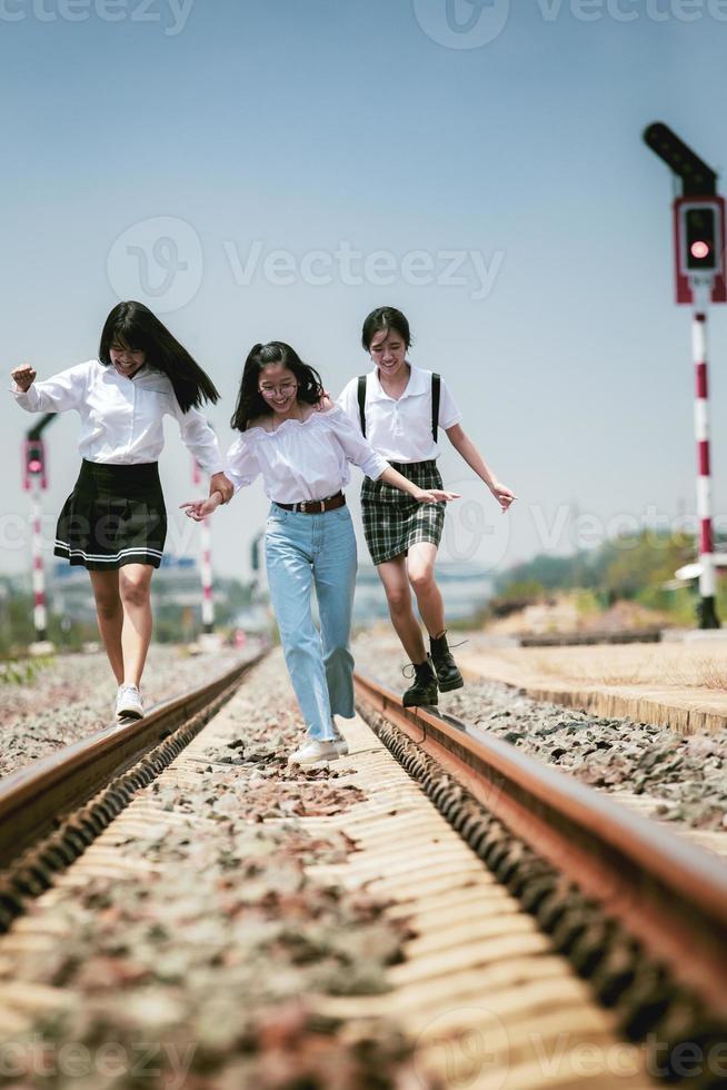 grupp glada tonåringar kör med lycka på järnvägsspåret foto