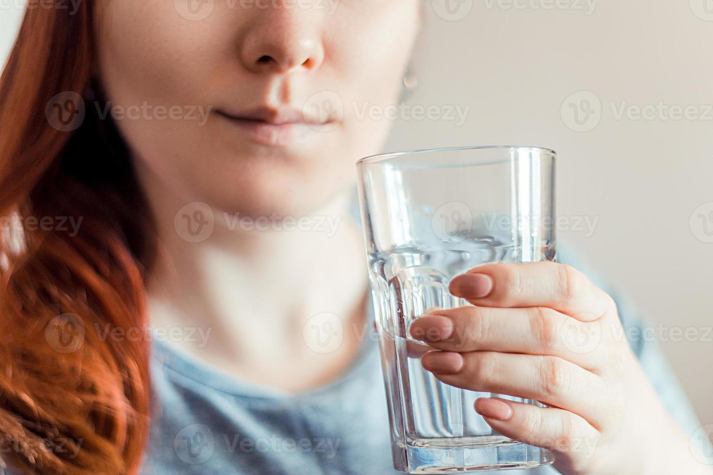 kvinna som håller ett glas rent vatten i händerna. världs vatten dag. hälso-och sjukvård koncept. foto