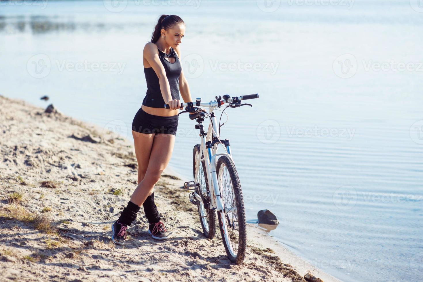 kvinna på en cykel nära vattnet foto