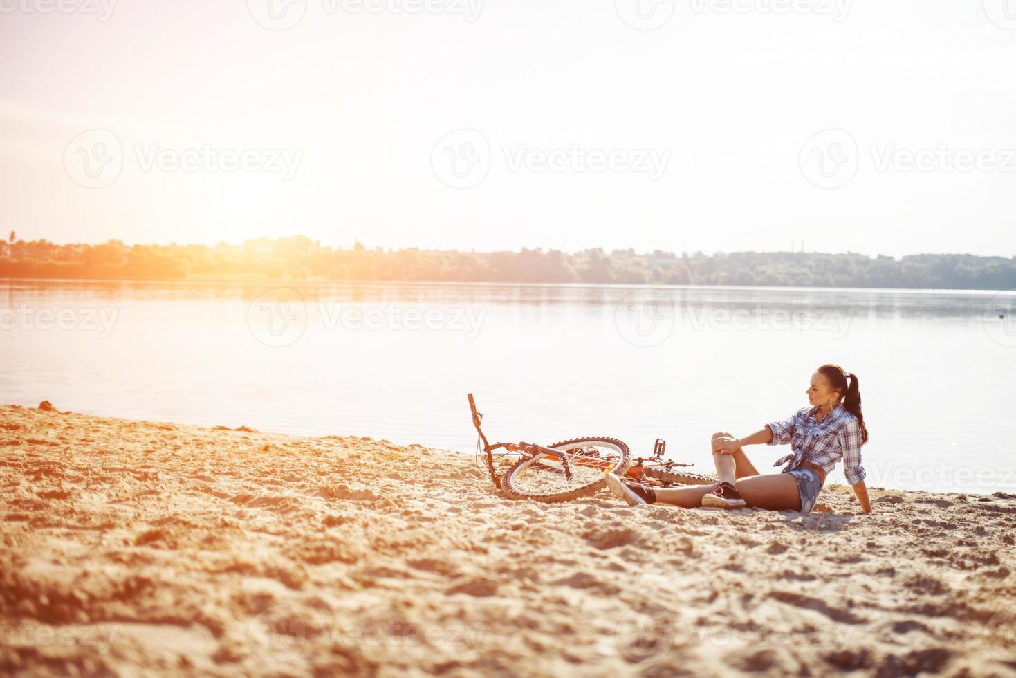 kvinna på en cykel på stranden foto