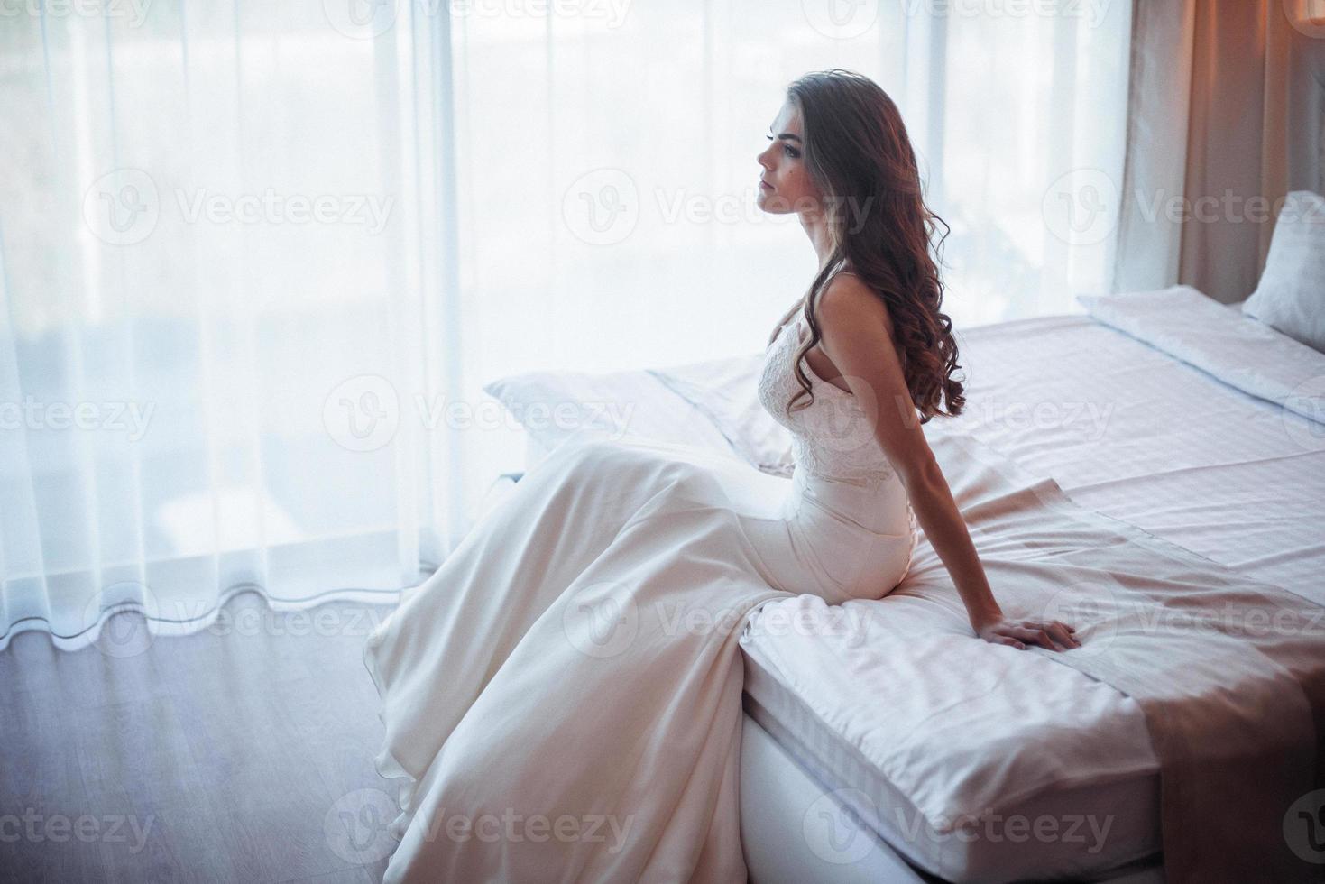 bruden sitter på sängen foto