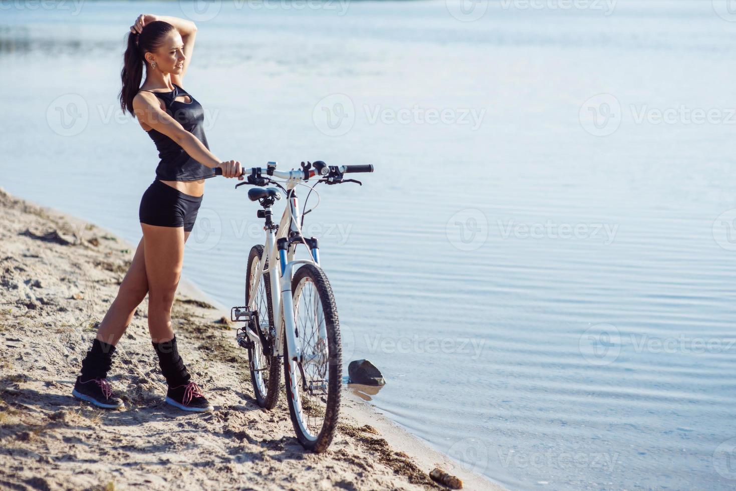 kvinna på en cykel på stranden foto