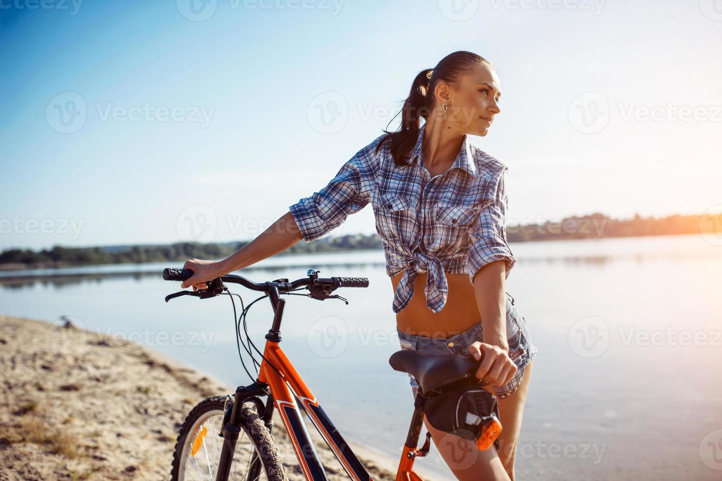 kvinna på en cykel på stranden foto