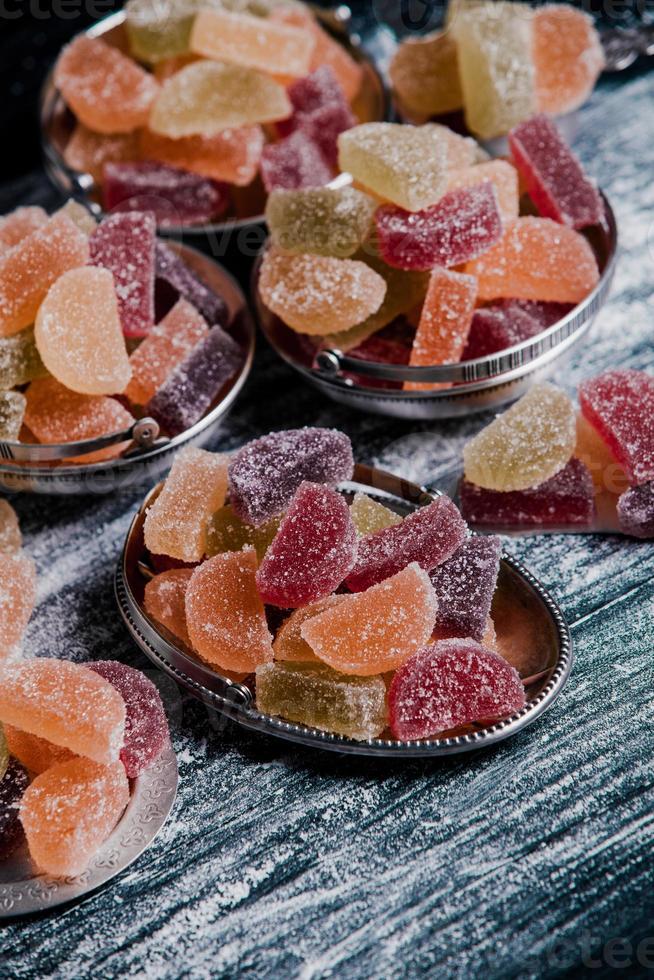 samling av färgglada marmeladljus. sött bord med bonbonburkar. foto