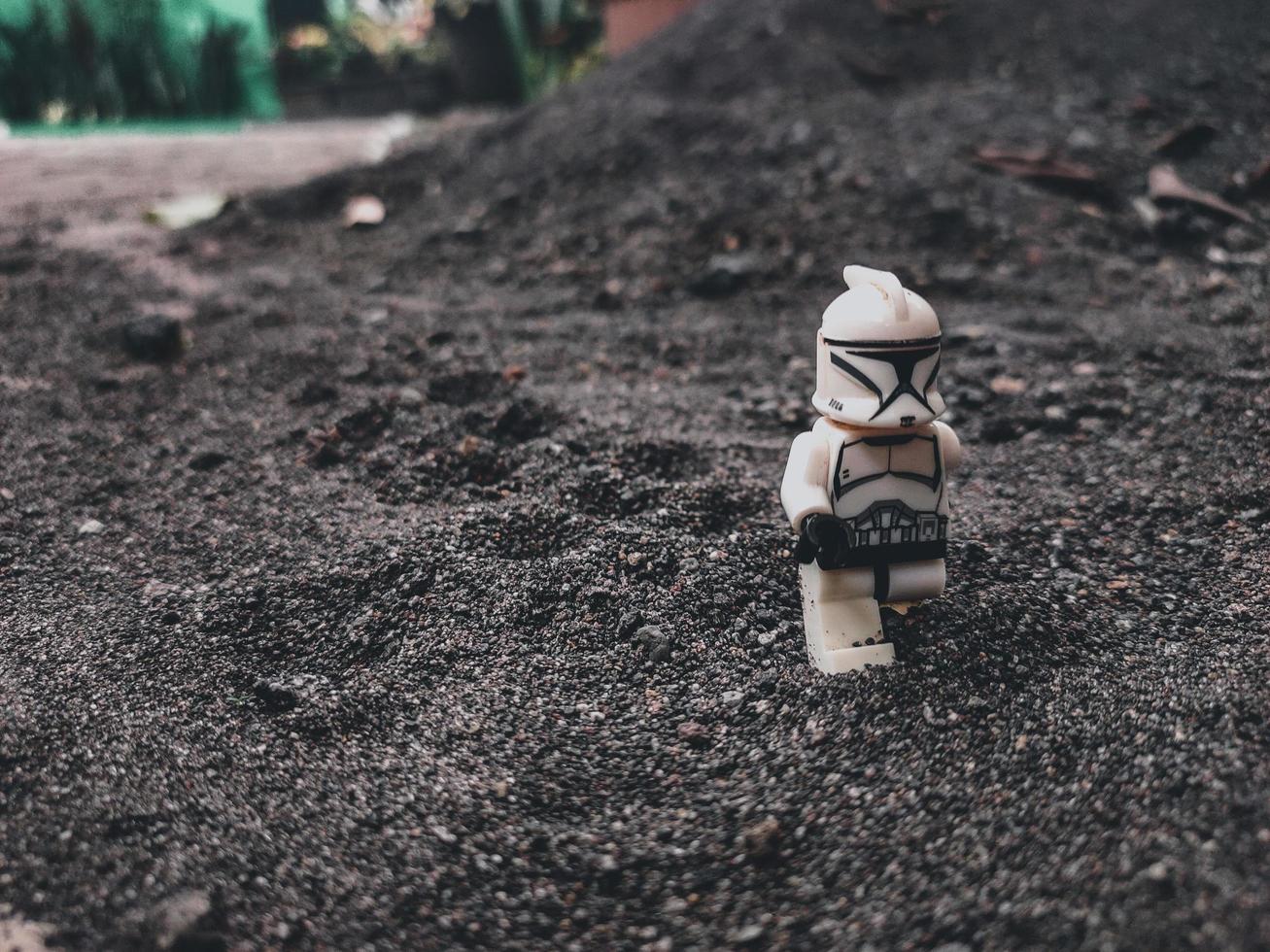 en actionfigur klontrooper med svart sandbakgrund foto