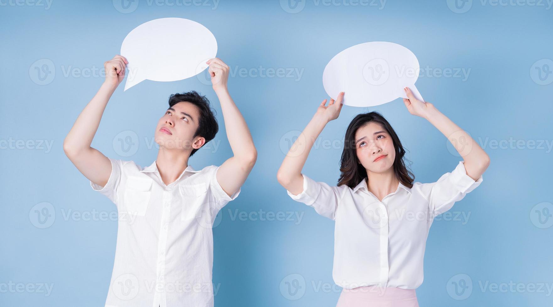 bild av unga asiatiska par håller meddelande bubbla på blå bakgrund foto
