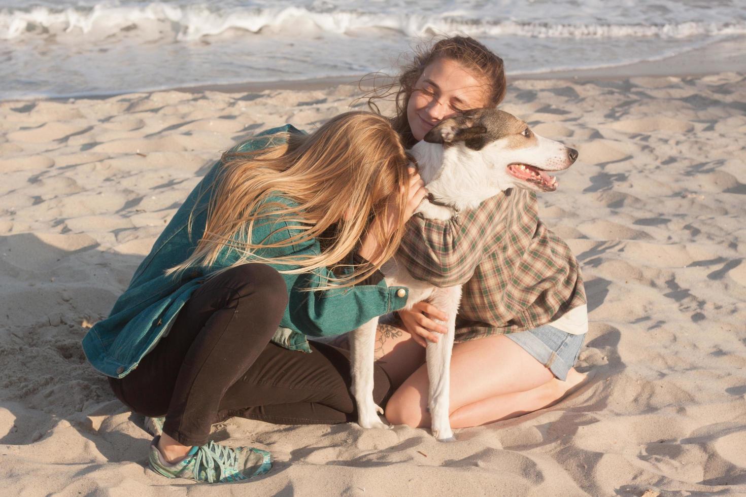 kvinna leker med hund på stranden foto