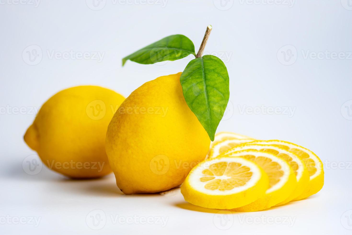citronen och citronskivan på den vita bakgrunden foto