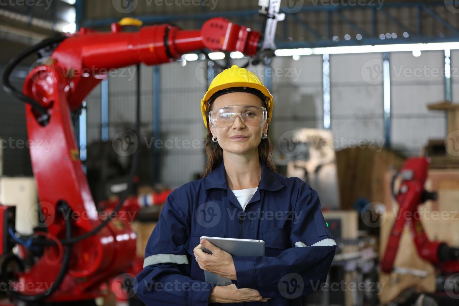 olika mångkulturella tungindustriingenjörer och arbetare i uniform kontrollerar automatik robotarm för fabriksanvändning. kvinnlig industrientreprenör använder en surfplatta. foto