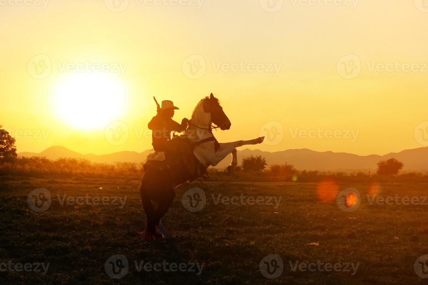 cowboy till häst mot en vacker solnedgång, cowboy och häst vid första ljuset, berg, flod och livsstil med naturligt ljus bakgrund foto