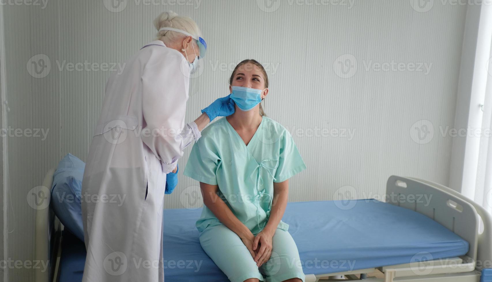 Coronavirusskydd under karantänen, kvinnlig läkare gör medicinsk undersökning till en kvinnlig patient. foto