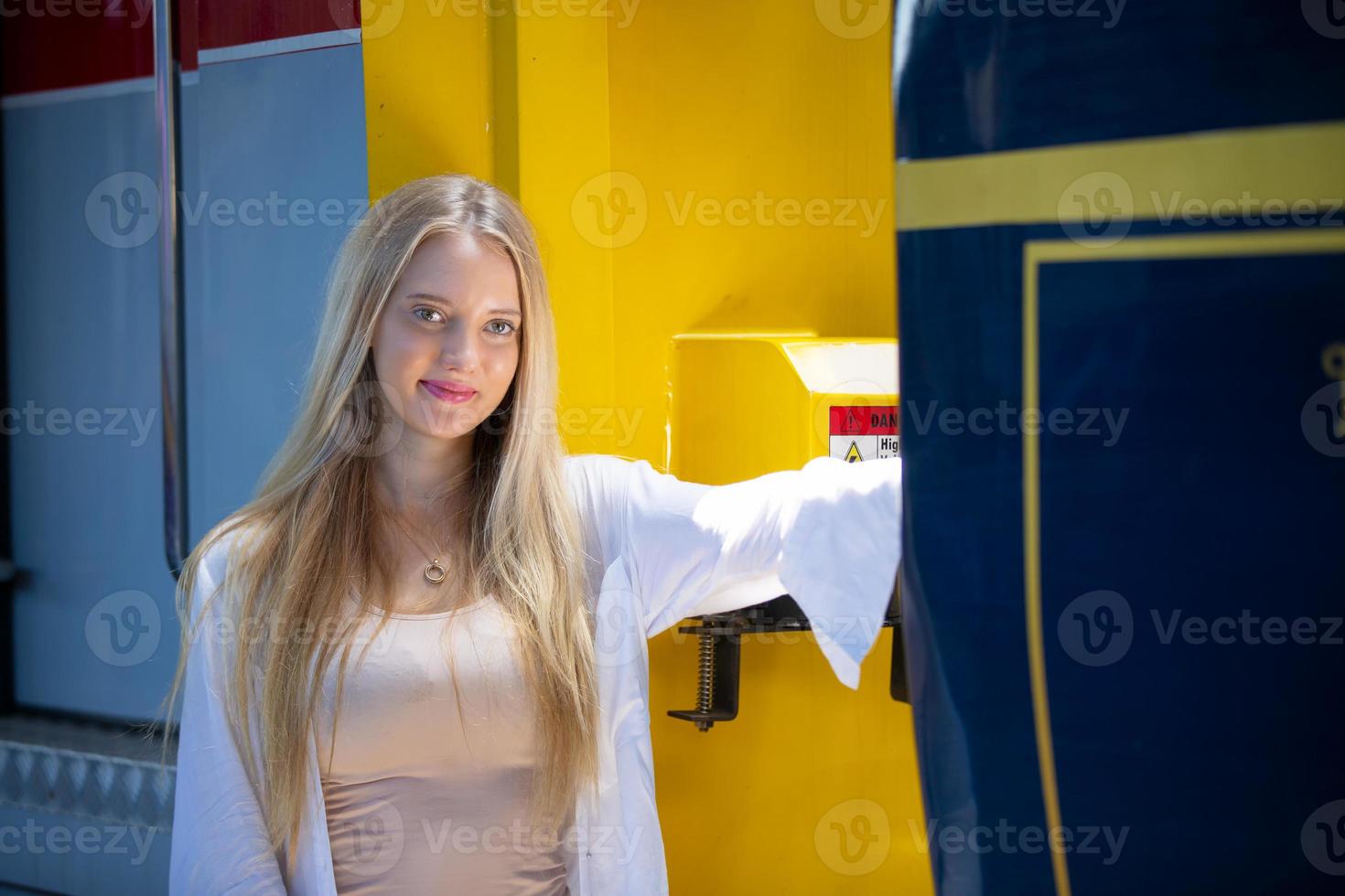 porträtt av en vacker blond ung kvinna som står vid tåg. foto