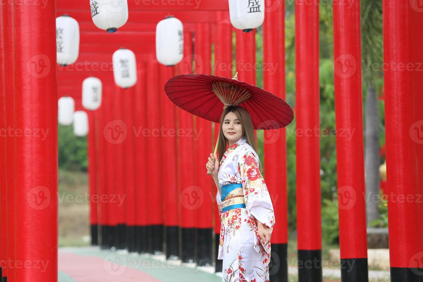 ung asiatisk flicka som bär kimono japanska traditionella kläder och rött paraply. foto