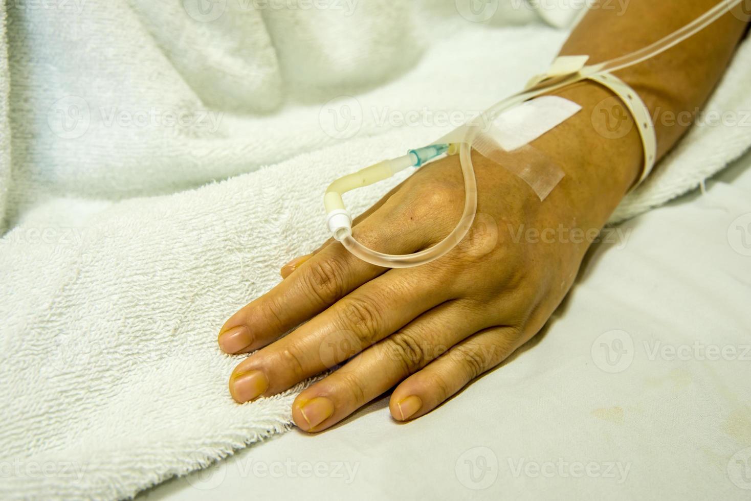 hand av kvinna patient inlagd på sjukhuset med saltlösning intravenöst foto