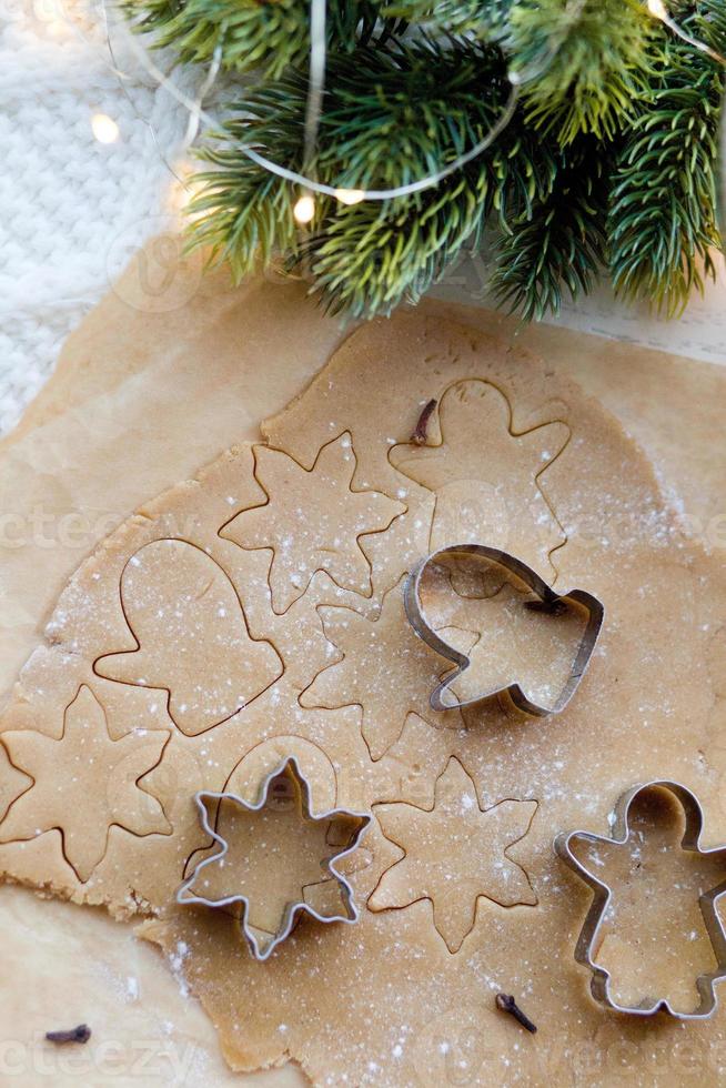 ingefärsdeg för jul pepparkakor och kakformar på bordet foto