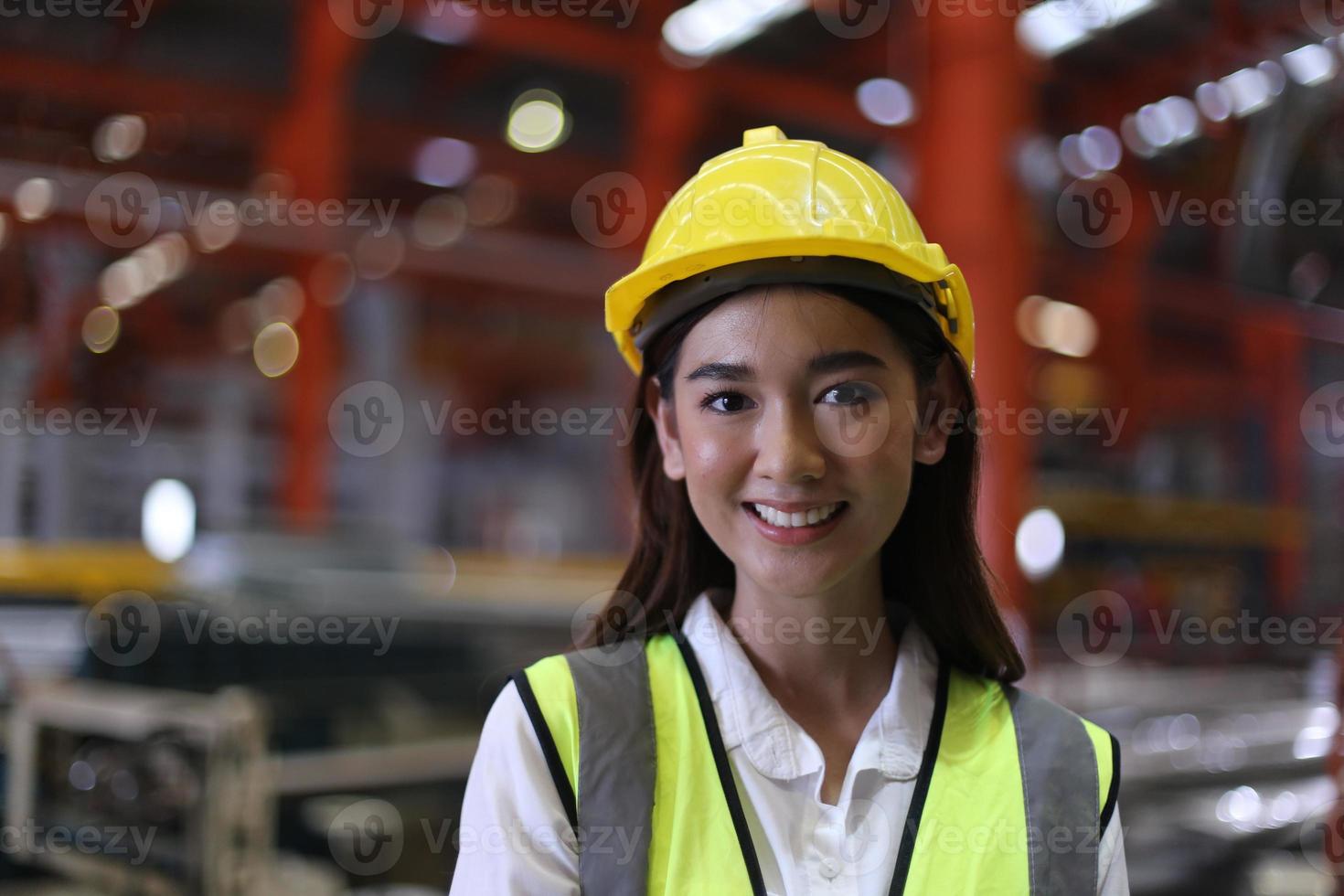 kvinnlig arbetare förman eller arbetare arbete på fabriksplatsen kontrollera maskin eller produkter på plats. ingenjör eller tekniker som kontrollerar material eller maskin på anläggningen. industri och fabrik. foto