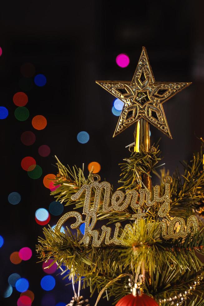 vackert juldekorationskoncept, grannlåt som hänger på julgranen med gnistrande ljusfläck, suddig mörk svart bakgrund, makrodetalj, närbild. foto