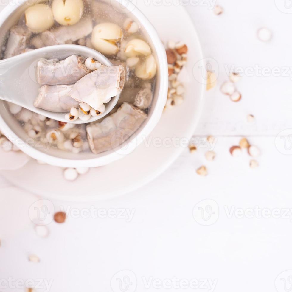 välsmakande fyra tonics örtsmakssoppa, taiwanesisk traditionell mat med örter, fläsktarm på vitt träbord, närbild, platt låg, ovanifrån. foto