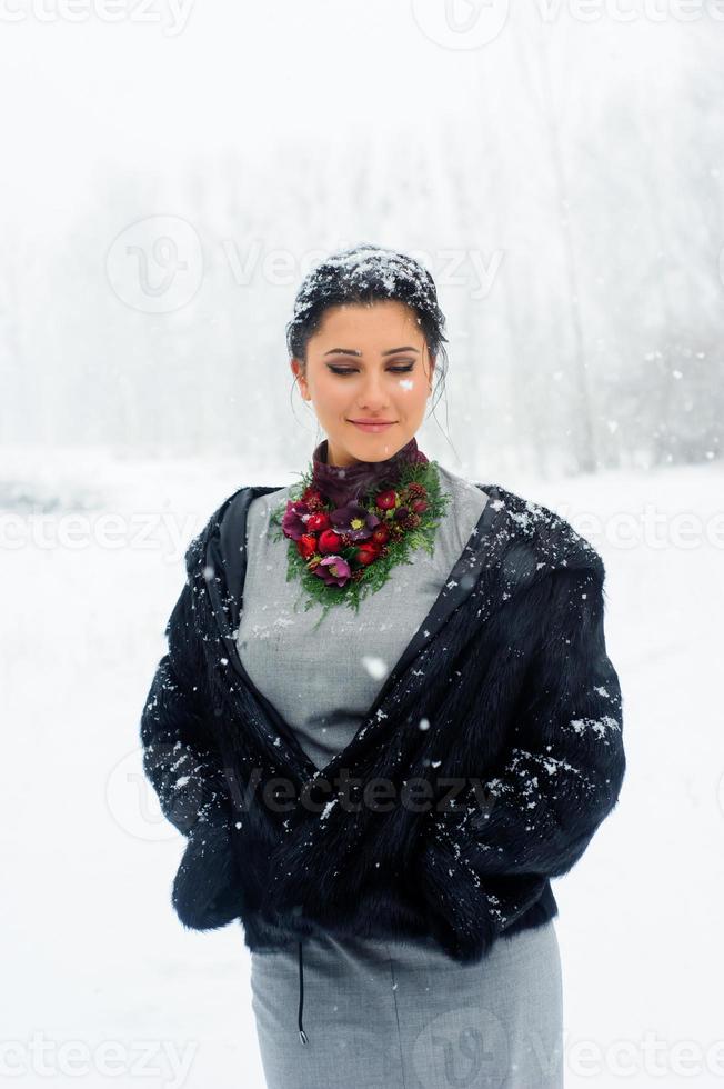 flickan går förbi vägen som är täckt av snö. många snöflingor flyger i luften, en snöstorm kommer. foto