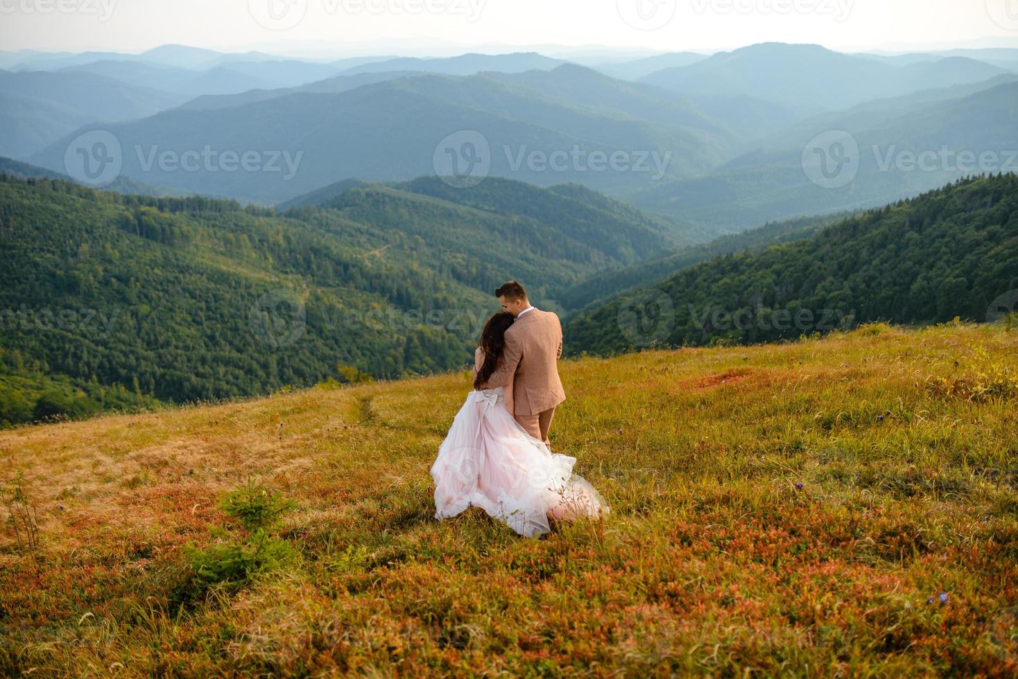 eleganta unga bruden och brudgummen står i båten på bakgrunden moln himmel havet och bergen i montenegro foto